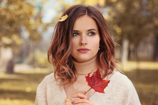 Modelo de mujer de otoño romántico con cabello castaño, con chica de moda de otoño al aire libre