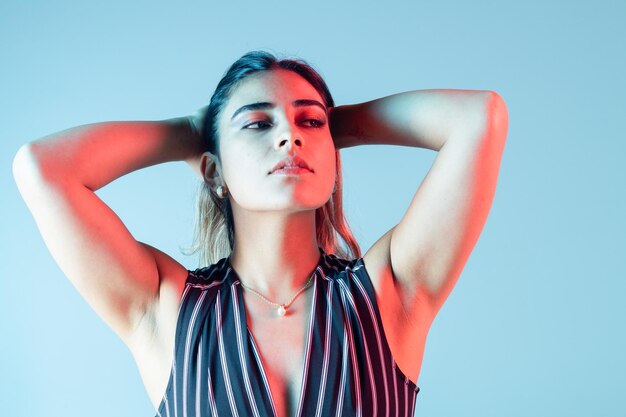 modelo de mujer rubia de moda moderna con traje a rayas en un fondo colorido aislado en un estudio fotográfico