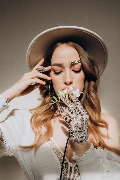 Modelo mujer con sombrero y joyas