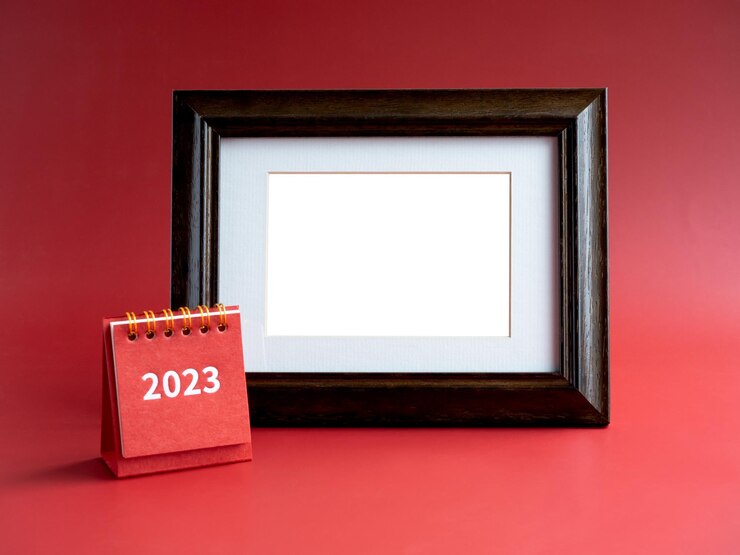 Foto modelo para moldura para cartão com pequeno calendário de mesa vermelho com número de 2023 anos no fundo vermelho minimalista espaço em branco vazio no porta-retrato de madeira vintage