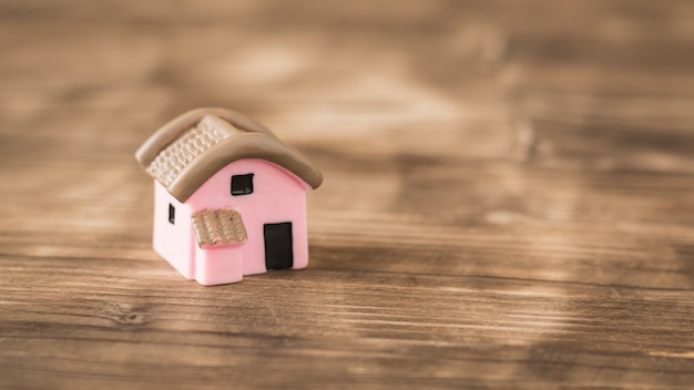 Modelo pequeña casa rosa en una mesa de madera