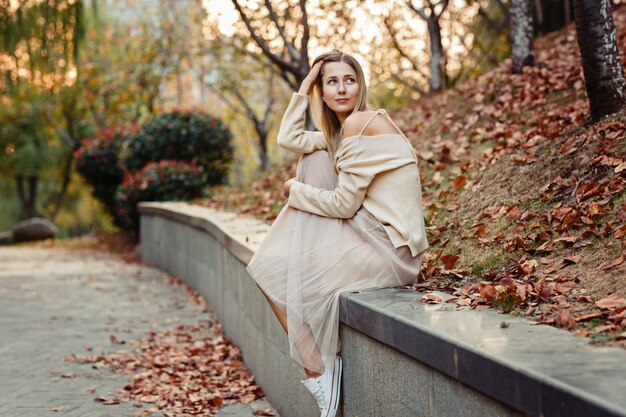 Modelo perfecto de mujer de otoño con cabello rubio al aire libre