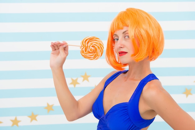 Modelo Pin-up feliz com pirulito na mão. Menina da moda com cabelo laranja se divertindo. Garota legal com pirulito. Mulher sexy. Garota maluca com humor brincalhão.