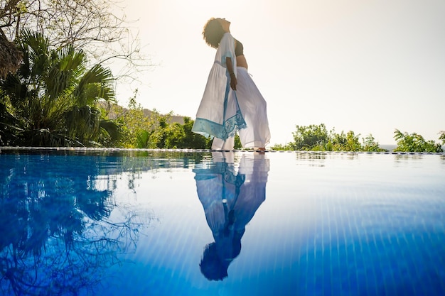 Modelo posando junto a una piscina tropical al aire libre