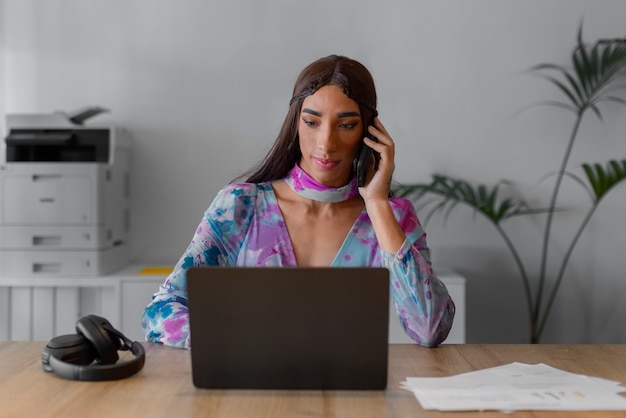 Foto modelo queer de tiro médio trabalhando com laptop