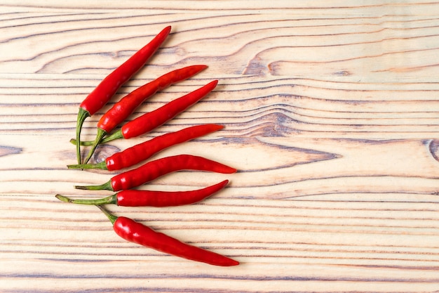 Modelo rojo fresco de las pimientas de chile en fondo de madera.