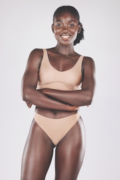 Modelo de ropa interior de mujer negra y cuerpo en estudio de moda belleza o cuidado del cuerpo de fondo blanco Ropa interior de mujer africana feliz o cosméticos corporales de bikini o bienestar de la piel con sonrisa orgullosa y salud