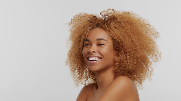 Modelo rubio negro de raza mixta con cabello rizado en cabello rubio afro blanco