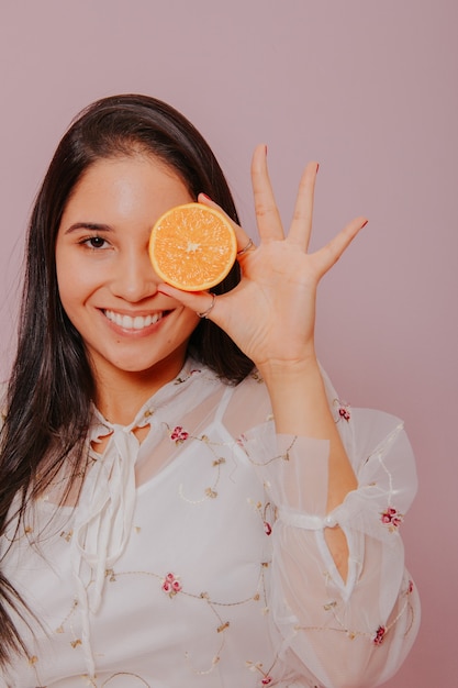 Modelo sosteniendo una naranja.