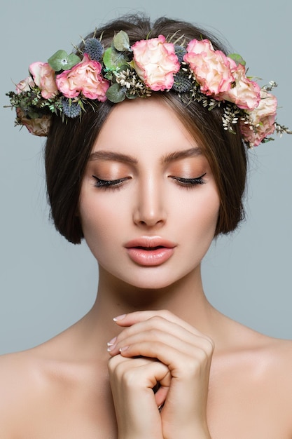 Modelo de spa de mujer sana con flores de primavera y piel fresca, primer plano de rostro femenino joven