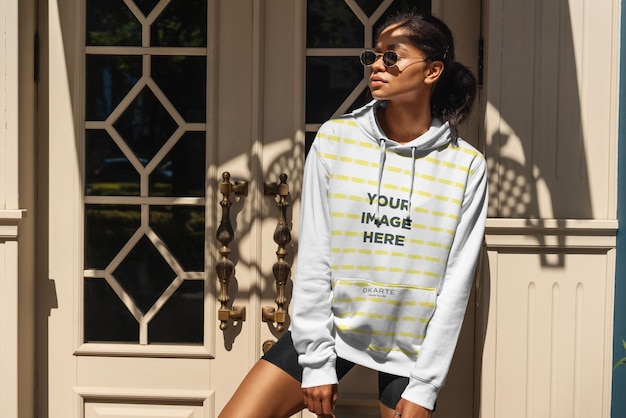 Modelo de sudadera con capucha de una mujer frente a una puerta
