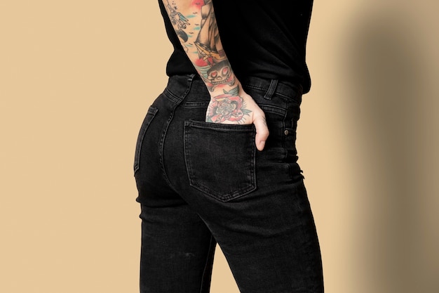 Modelo con tatuaje en jeans y camiseta negra