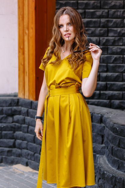 Modelo con un vestido amarillo claro en la calle