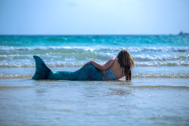 modelo con un vestido de sirena en el mar.