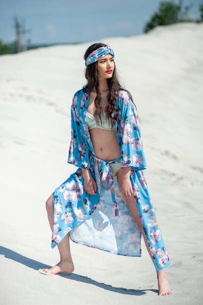 Una modelo viste un kimono azul con un estampado floral.