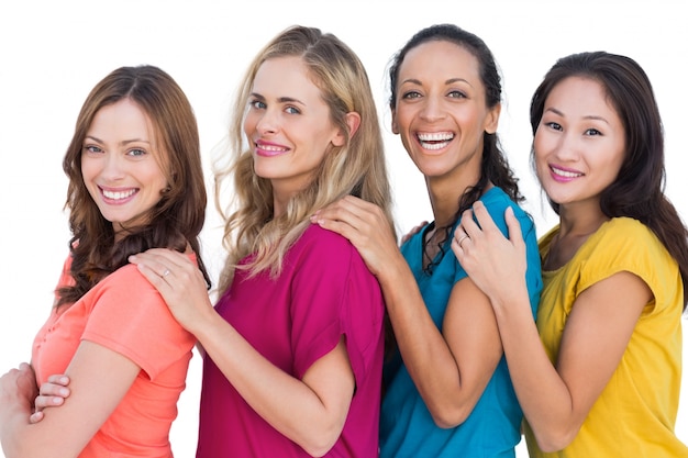 Modelos alegres em uma linha posando com t-shirts coloridas