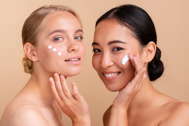 Modelos de close-up com creme facial posando juntos