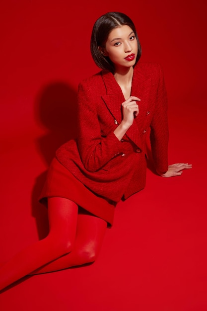 Modemodell aus Asien in roter Jacke und Rock