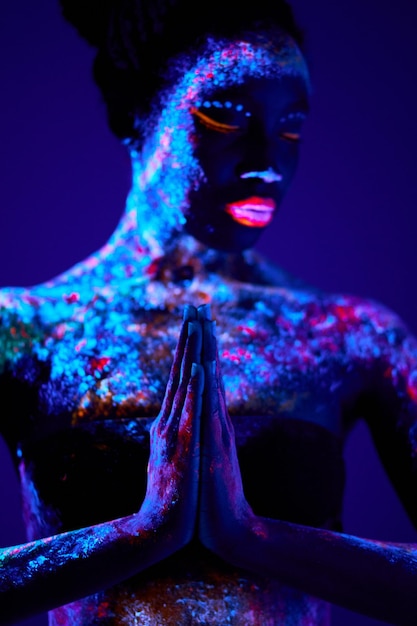 Modemodellfrau im Neonlichtmodell mit fluoreszierendem Make-up in Gebetsposition Kunstdesign der Frau ...