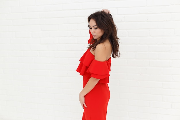 Modeporträt der Frau im roten Kleid auf hellem Hintergrund