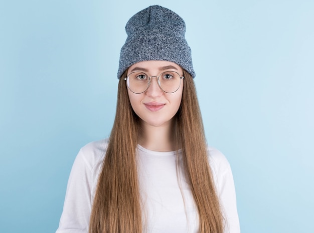 Modeporträt der hübschen jungen Hipster-Brünettenfrau, die stilvolles städtisches T-Shirt und Hut trägt,