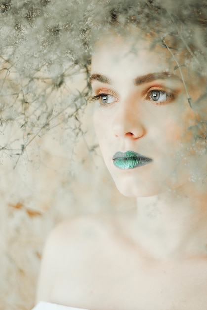 Modeporträt der jungen blonden Frau. Schöne Frau mit den grünen Lippen. Konzept der Mutter Natur