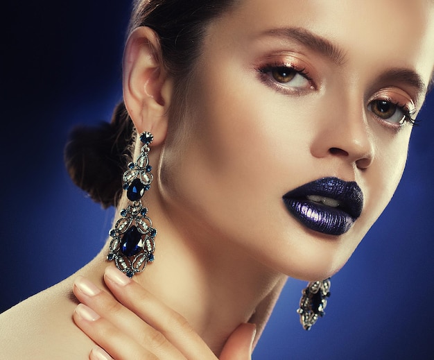 Modeporträt der jungen schönen Frau mit Schmuck Perfektes Make-up Blaue Lippen