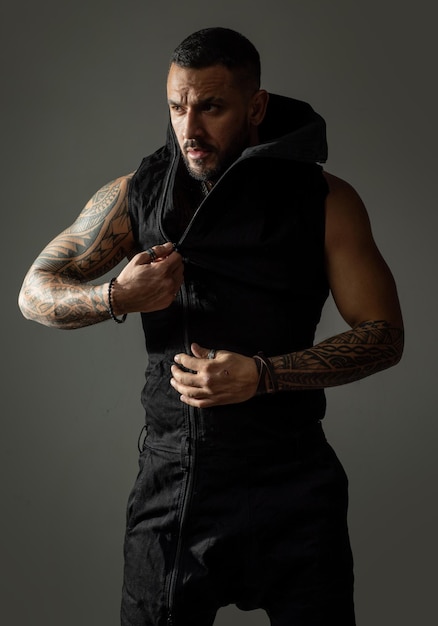 Modeporträt eines selbstbewussten und gutaussehenden jungen Mannes auf grauem Wandhintergrund