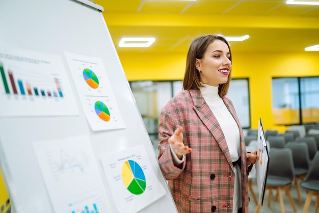 Moderatorin der jungen Frau hält eine Geschäftspräsentation auf einer Konferenz im Büro