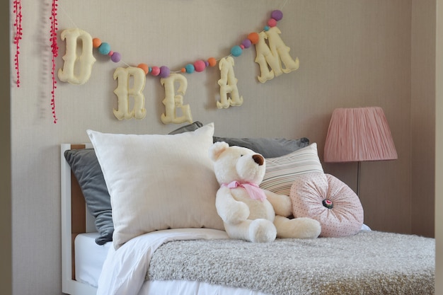 Foto modern kids room com boneca e travesseiros na cama