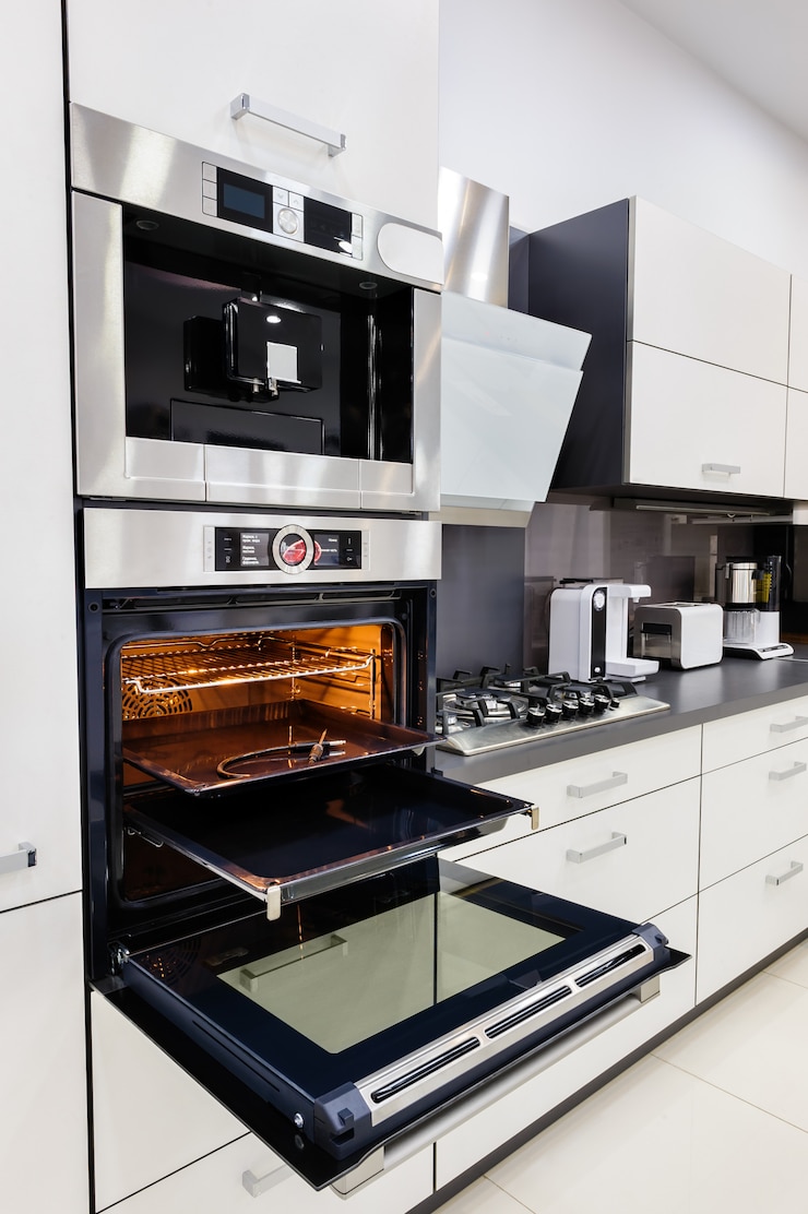 Foto moderna cocina hi-tek a medida, horno con puerta abierta.