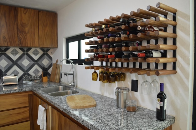 Moderna cocina de madera con barra de granito negro o gris con placa para salpicaduras de azulejos y suelo claro