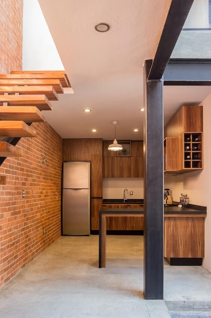 Moderna cocina de madera con barra de granito negro o gris con placa para salpicaduras de azulejos y suelo claro