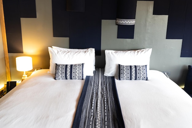 Moderna combinación de cama blanca y almohada azul oscuro de dormitorio de madera vintage de estilo asiático