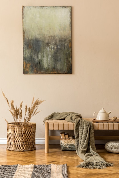 Moderna composición de salón con chaise longue de diseño, cuadros, cesto de mimbre con flores, tetera en la bandeja y elegantes complementos personales. Concpet coreano elegante de la decoración del hogar.