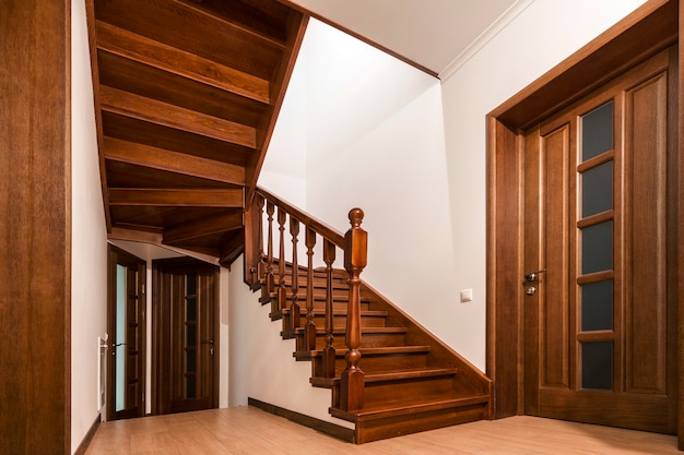Modernas escaleras y puertas de madera de roble marrón en el nuevo interior de la casa renovada