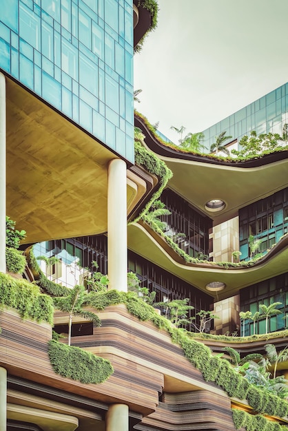 Moderne Architektur eines Balkons des Gebäudes mit vielen grünen Pflanzen. Modernes Design im Zentrum von Singapur.