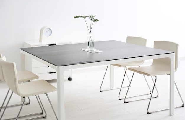 Moderne Büroeinrichtung mit großem Tisch und weißen Stühlen