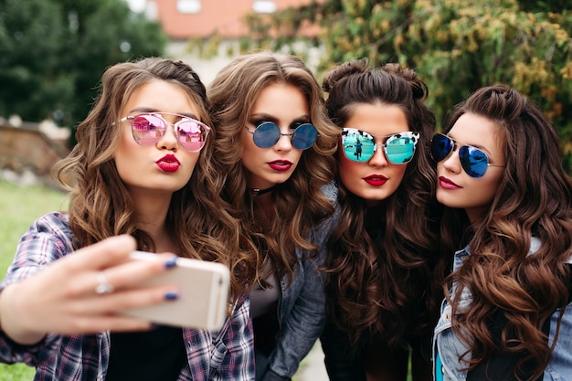 Moderne Damen mit der Frisur, die draußen selfie nimmt.