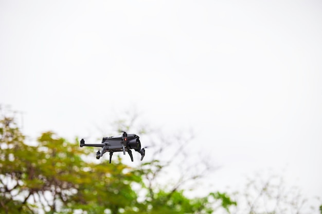 Moderne Drohne fliegt im Wald Dunkle Drohne in der Luft dagegen