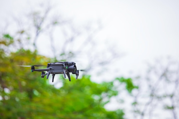 Moderne Drohne fliegt im Wald Dunkle Drohne in der Luft dagegen