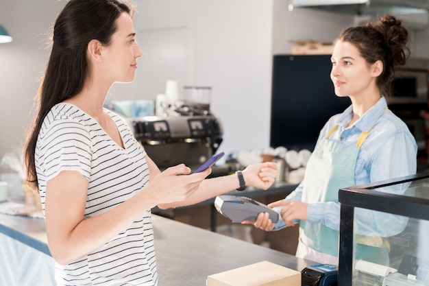 Moderne Frau, die durch Smart Watch zahlt