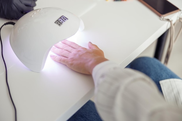 Moderne Frau während der Nagelpflege im Salon