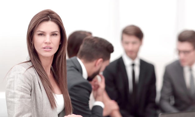 Moderne Geschäftsfrau auf dem Hintergrund der Bürogeschäftsleute