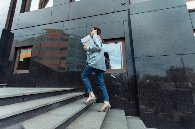 Moderne Geschäftsfrau erklimmt die Treppe in der Nähe des Business Center Lifestyle