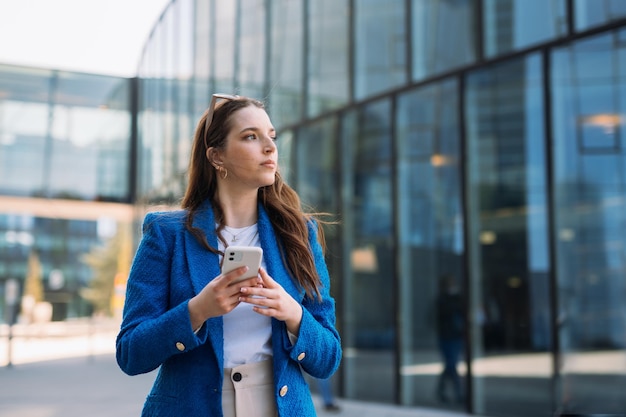 Moderne Geschäftsfrau im blauen Anzug mit Handy copyspace hochwertiges Foto