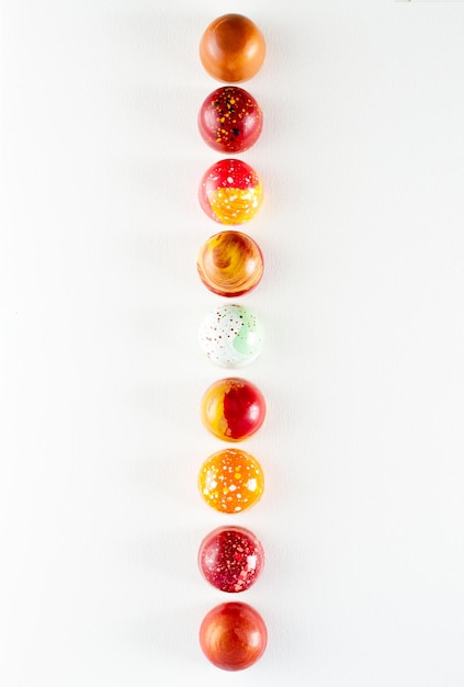 Moderne handbemalte Pralinen in verschiedenen Farben in einer Reihe Produktwerbekonzept