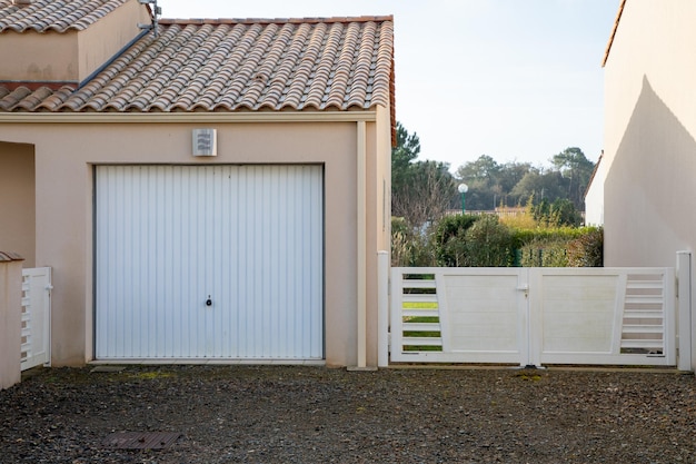 Moderne Hausfassade mit modernem weißem Garagentor und Portal-PVC-Tür