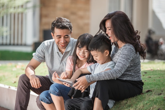 Moderne junge Familie mit Tablette