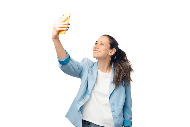 Moderne junge Frau macht ein Selfie von sich selbst in einem Studio.